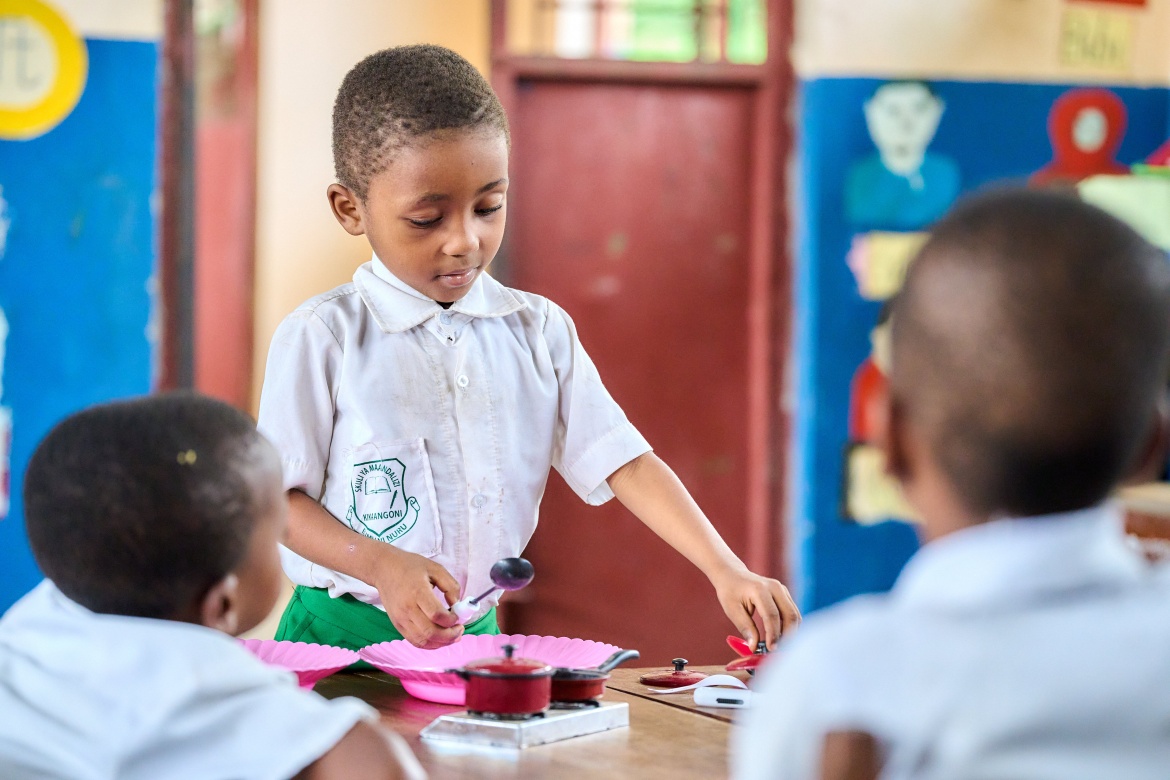 Un élève de 2e année de maternelle, Kassim Khamis Ali, utilise des objets lors d’une séance de jeu sur le thème de la cuisine, aux côtés de ses camarades au Centre TuTu de Kikaangoni, à Zanzibar. 