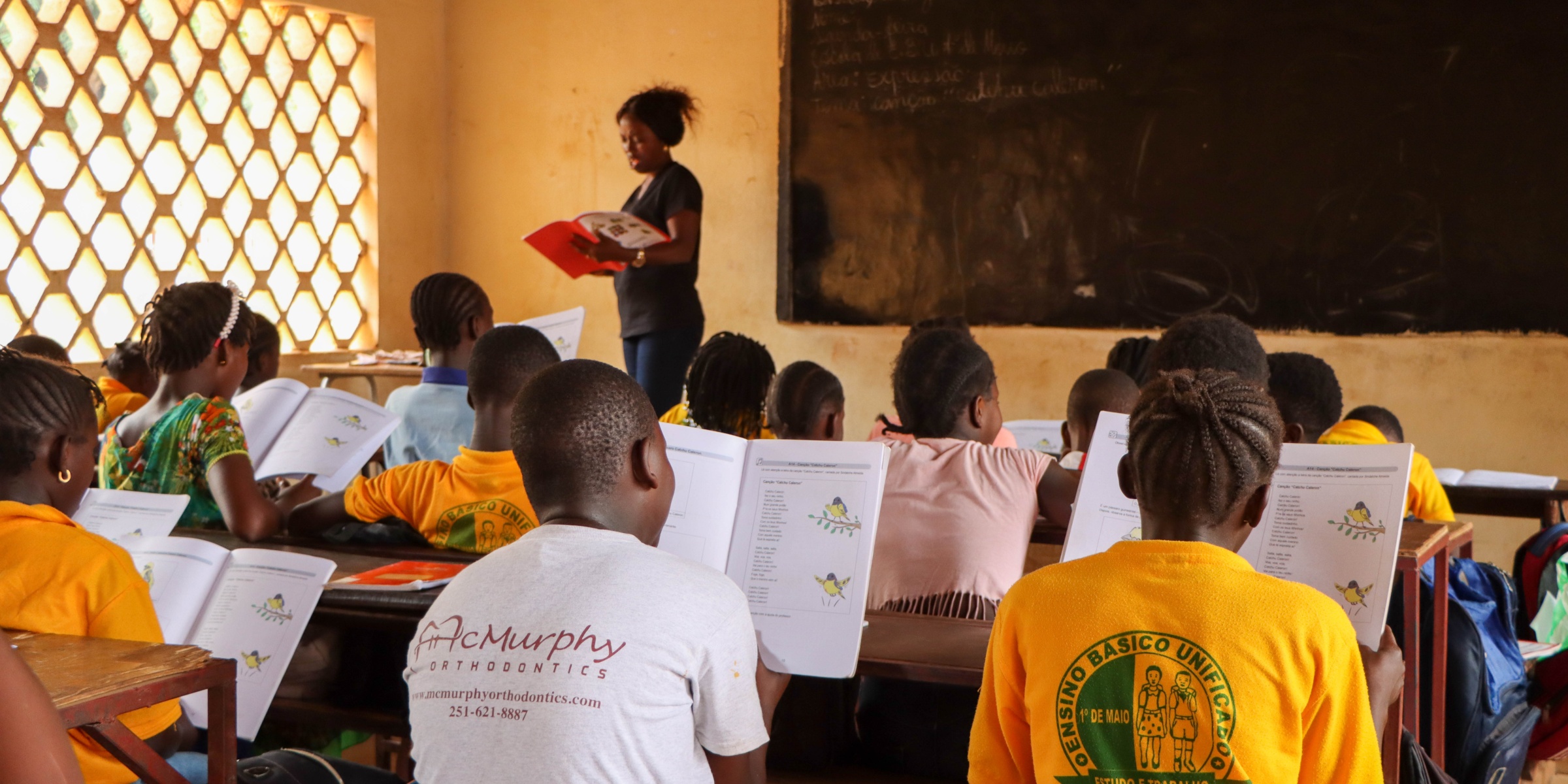 Teacher Maria Isabel Nhoque and grade 4 students at 1º de Maio Primary School in Bissau use new textbooks, Guinea-Bissau. Credit: Joana Rodrigues/World Bank