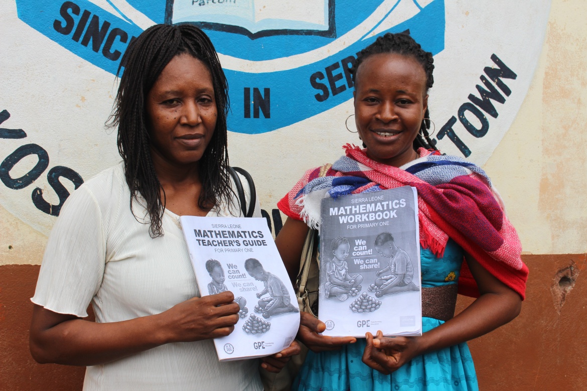 Catherine Mansaray and Martha Mansaray, grade 1 teachers at the Freetown Polytechnique Practicing Primary School display the teachers' guide and pupils' workbook on numeracy. Credit: UNICEF Sierra Leone/2024/Davies